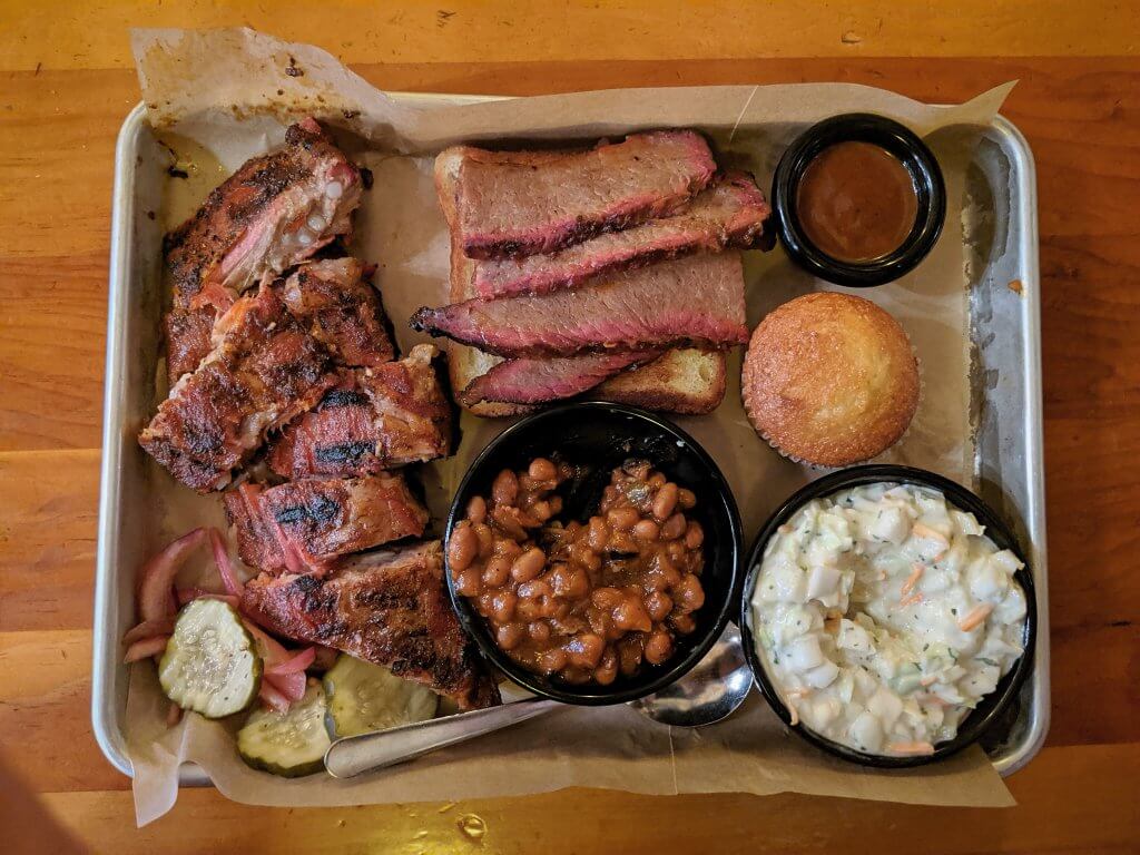 view of a tray full of barbecued meats and side dishes