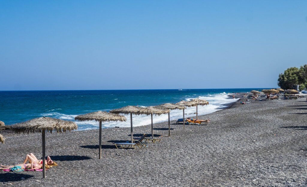 shoreline view of umbrellas along kamari beach in santorini greece