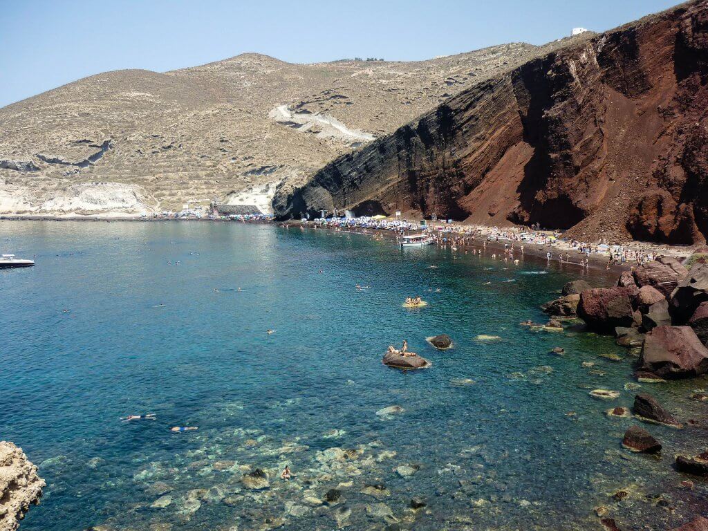 view of sunbathers on Santorini's red beach from above