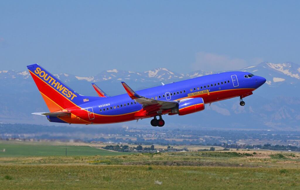 Southwest Airlines plane taking off with Denver mountains in the background